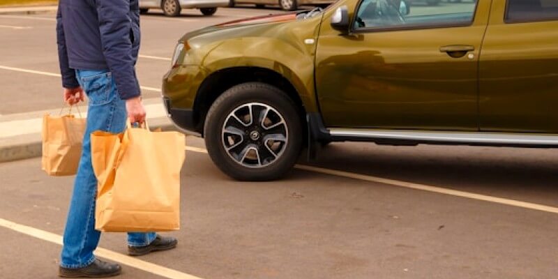 Homme à côté d'une voiture mal garée