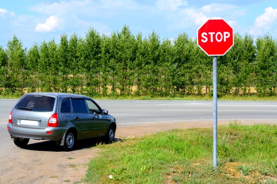 Voiture devant un panneau stop