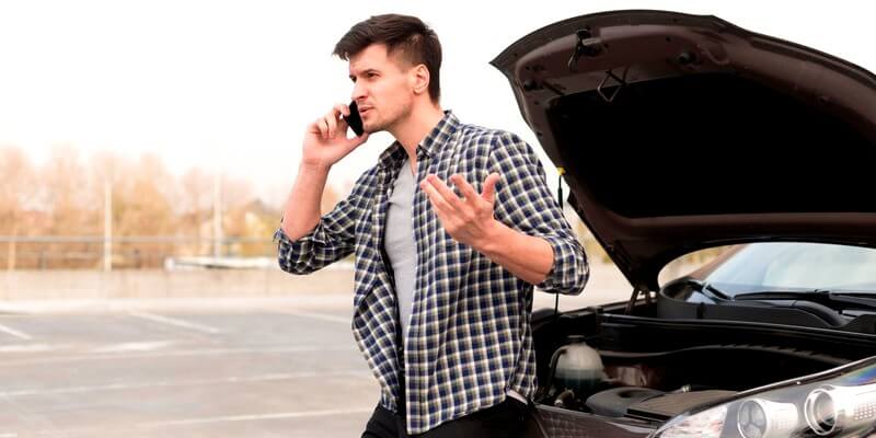 Homme qui est tombé en panne sur la route
