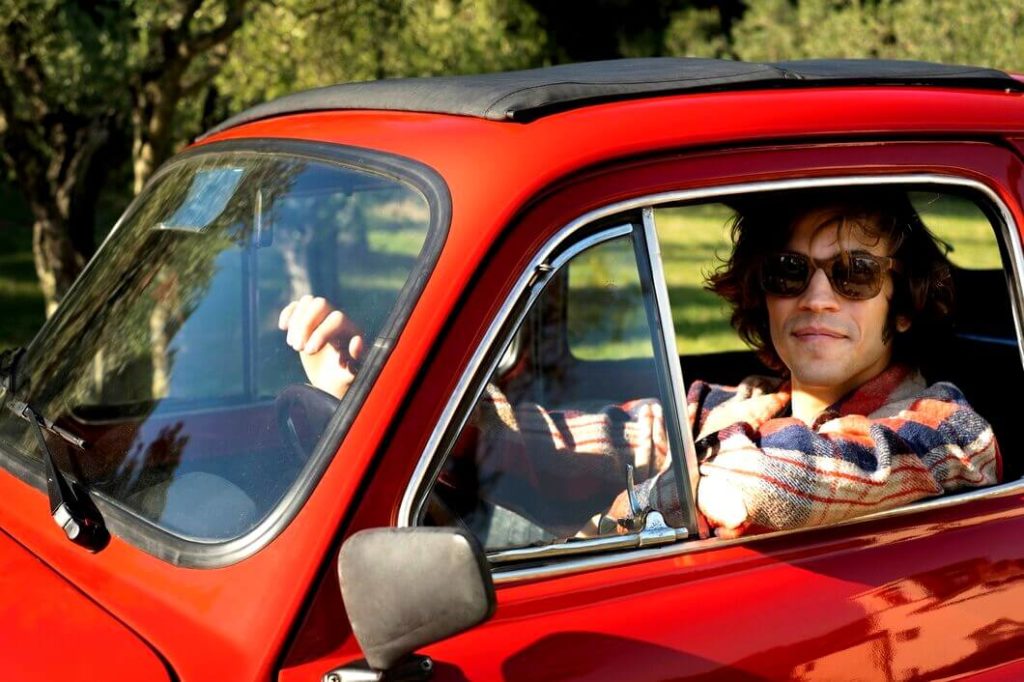 Jeune homme dans une voiture sans permis rouge