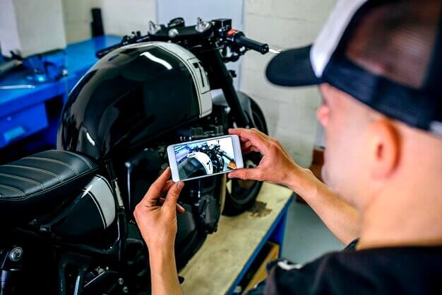 Homme qui photographie une moto